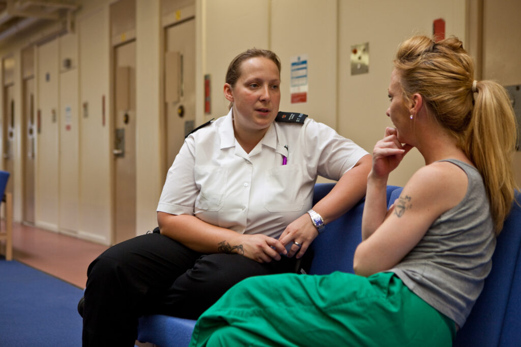 Women in prison talking to a prison guard Women in prison talking to a prison guard